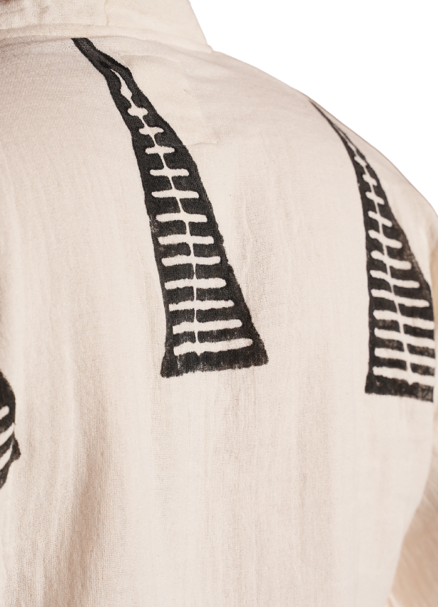 Close-up of black geometric tribal embroidery on beige organic cotton kimono, shoulder and back detail