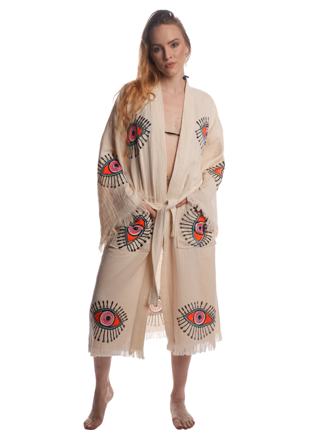 Front view of a model wearing the Pystantica Kimono made of organic Turkish cotton with red and black embroidered eye motifs.
