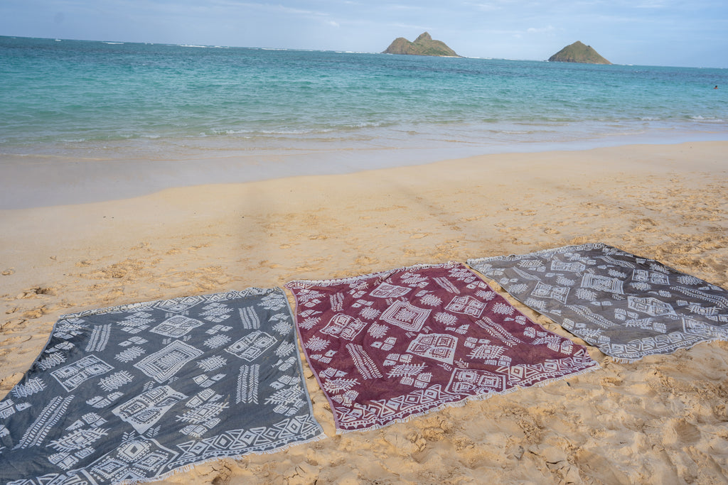 Organic boho blankets in neutral colors displayed on beach as large throws – Otantica Home.
