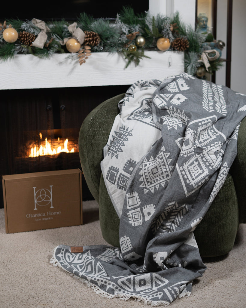 Reversible grey boho blanket styled in a cozy holiday living room – Otantica Home.