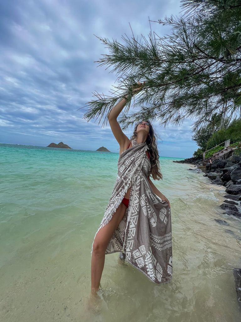 Woman cuddling her dog on a bed covered with a sand boho organic cotton blanket
